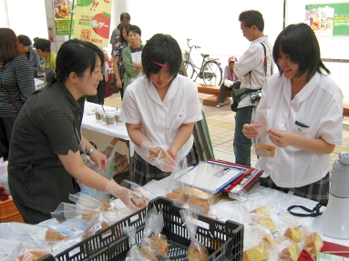 シフォンケーキの袋詰めをする鈴木さん（中央）と門脇さん（右）.jpg
